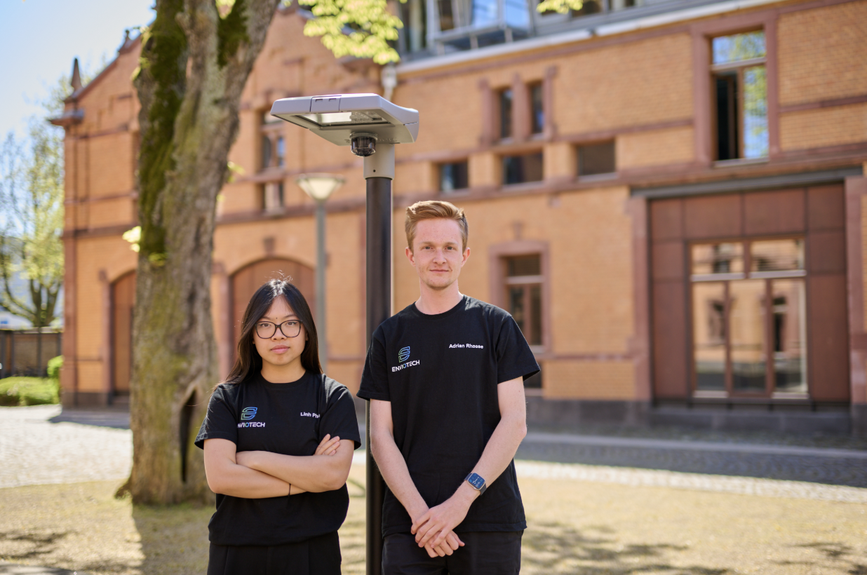 ENVIOTECH founders Linh Pham and Adrian Rhaese in front of a streetlight retrofitted with EnvioLux™