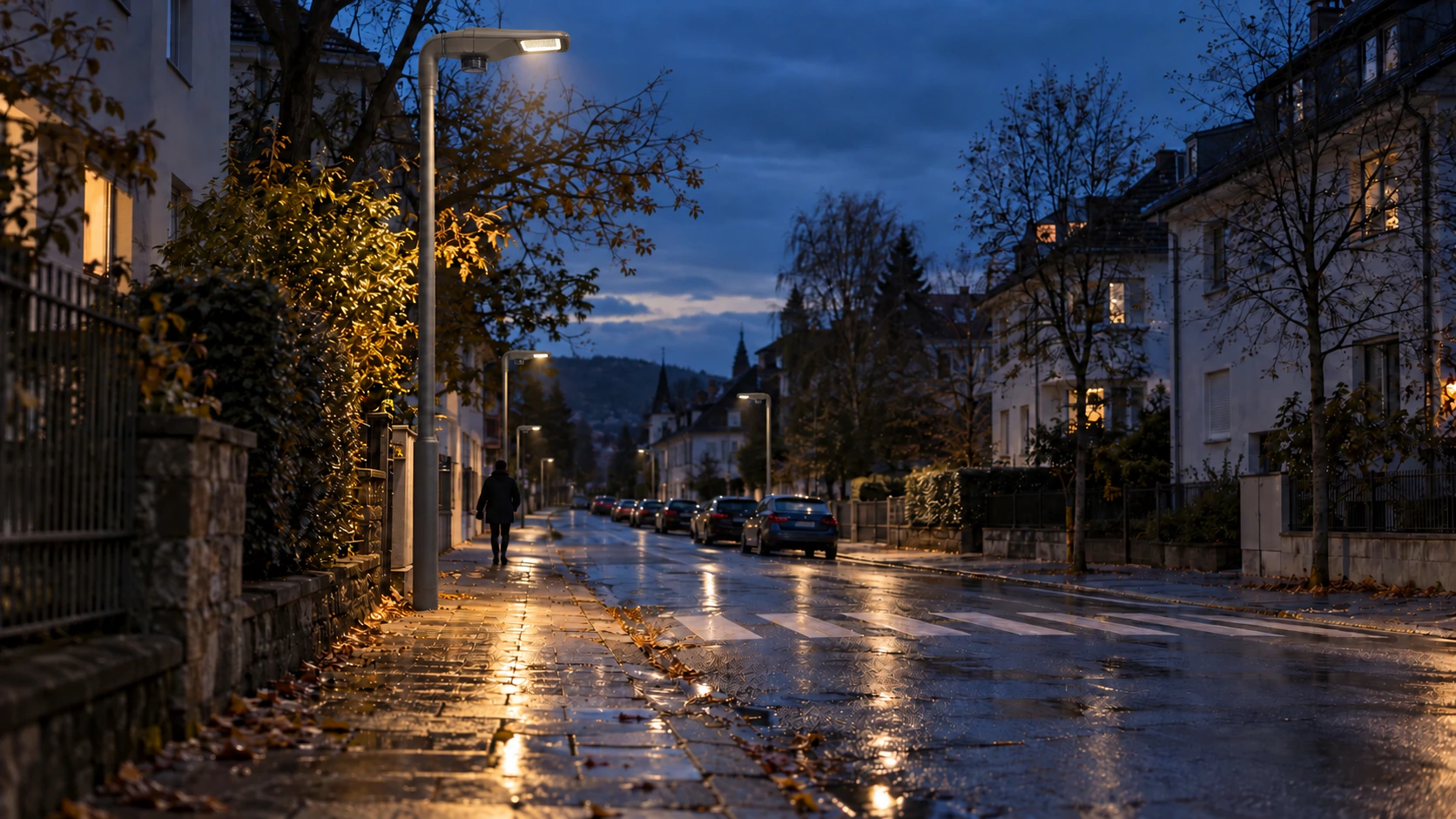 Beleuchtete Straße mit einem Fußgänger in der Abenddämmerung