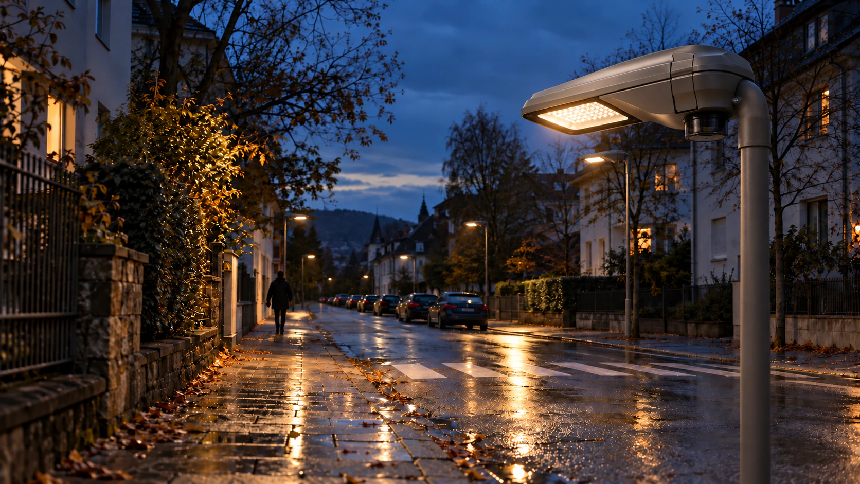 Residential street at dusk, streetlights illuminating the pavement and road